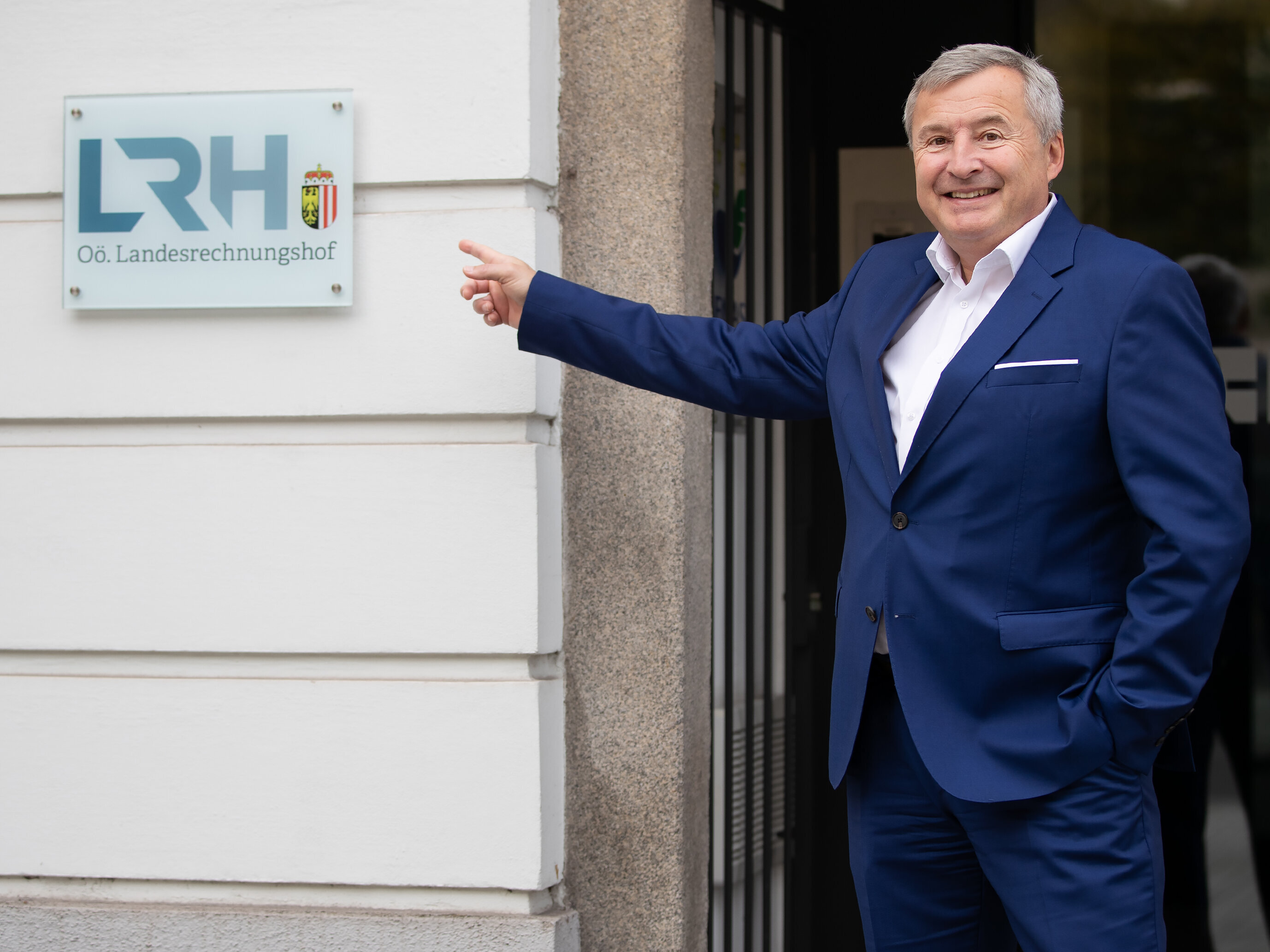 LRH Direktor Hoscher vor dem Türschild mit dem neuen Logo